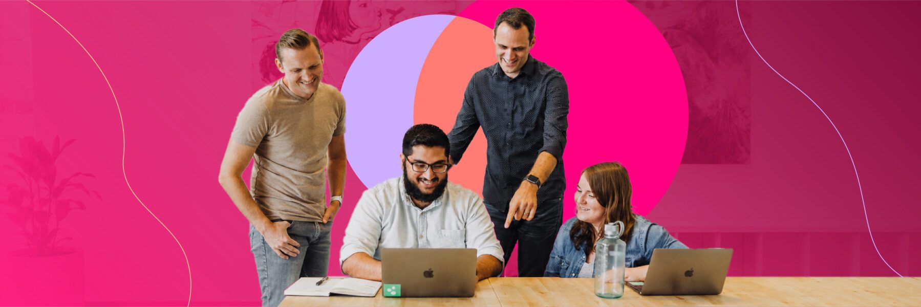 Four people gathered at a table with laptops, smiling and collaborating, with a bright pink and red abstract background.