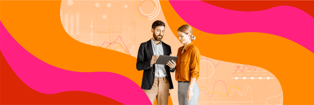 Two people in business attire look at a tablet together, standing against an abstract orange and pink background with charts and graphs.
