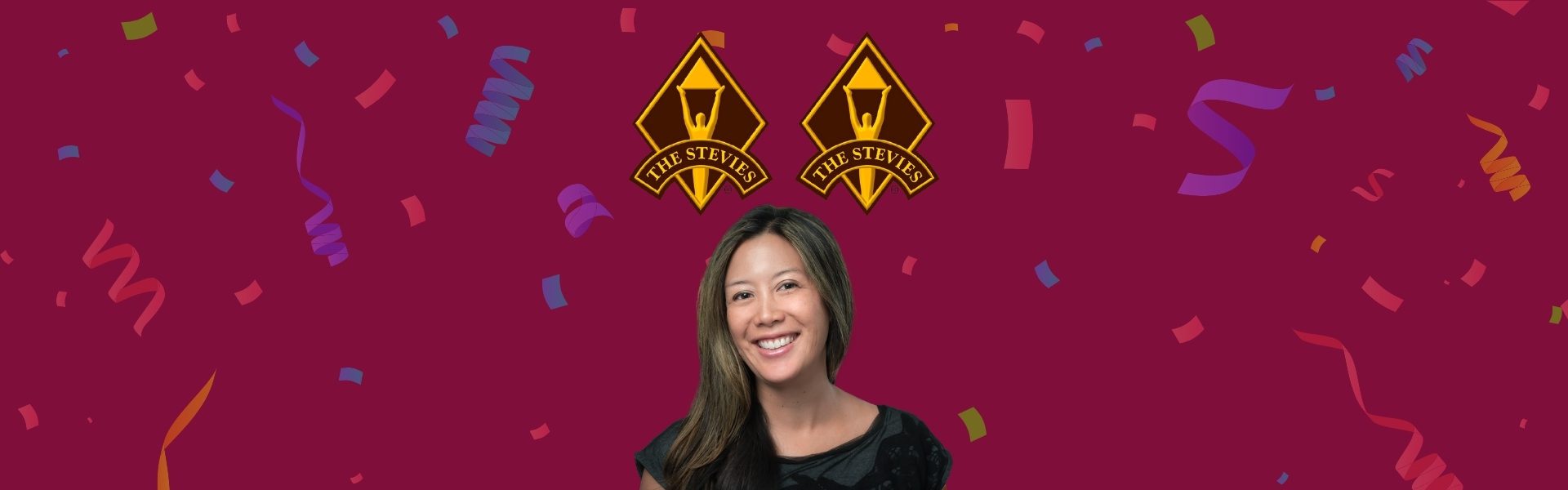 Woman smiling against a maroon background with confetti and two yellow and black logos reading "Lake Stevens.