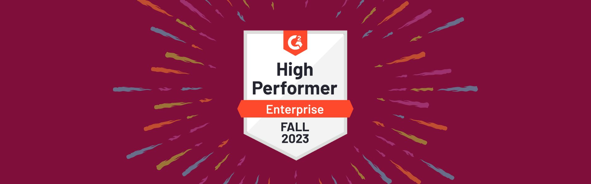 Badge reading "High Performer Enterprise Fall 2023" from G2, displayed on a maroon background with colorful radial lines.