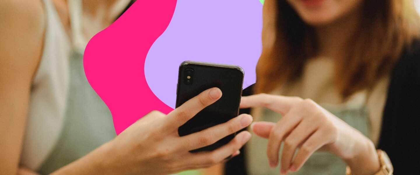 Two people looking at a smartphone screen, with a colorful abstract background.