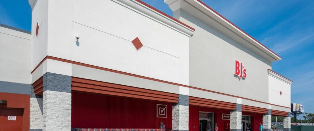 Exterior view of a BJ's Wholesale Club building with a clear blue sky.