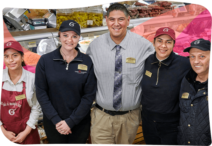 grocery store employees standing together in a group and smiling
