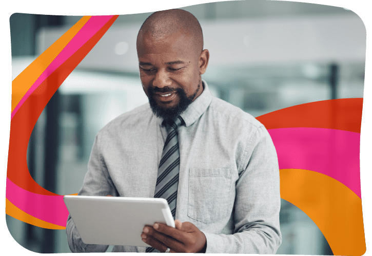 Man with a beard wearing a tie and shirt uses a tablet. Colorful abstract shapes in the background.