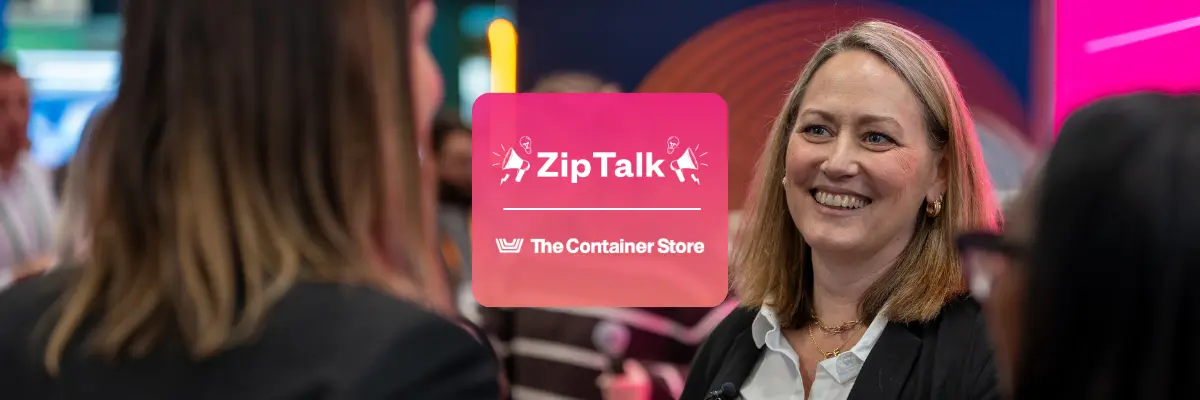 A woman smiles while speaking to another person at an event, with a Zip Talk and The Container Store logo overlay.