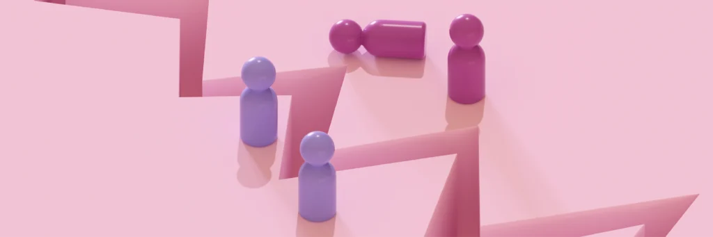 Four colored game pieces stand and lie on a pink, zigzagging surface with sharp edges and shadows.