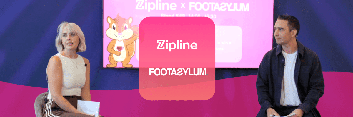 Two people sit on stage in front of a screen displaying "Zipline x Footasylum" with a cartoon character and event details in the background.