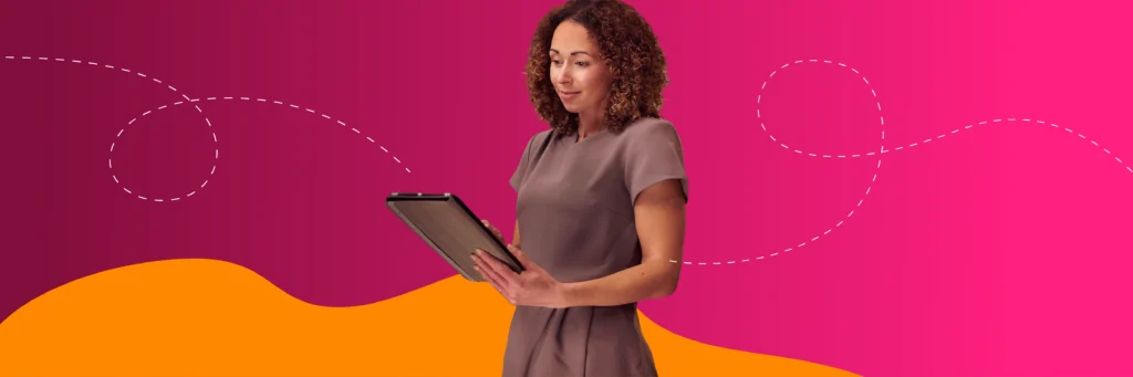 Woman with curly hair stands holding a tablet, looking at the screen. The background is pink with a yellow wave and white dotted lines.